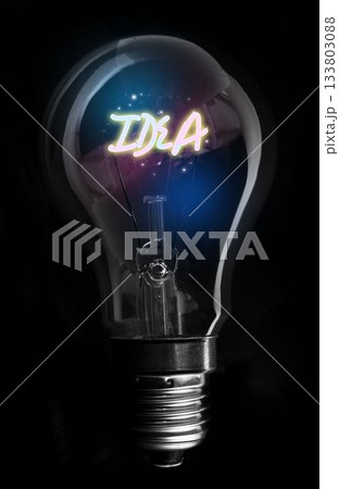 Showing glowing IDEA filament in incandescent bulb highlighting screw base, particles on black void Showing glowing IDEA filament in incandescent bulb highlighting screw base, particles on black void 133803088