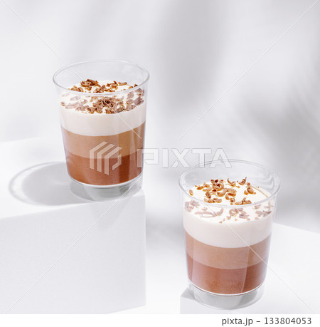 Delicious layered dessert served in clear cups at a trendy cafe Delicious layered dessert served in clear cups at a trendy cafe 133804053