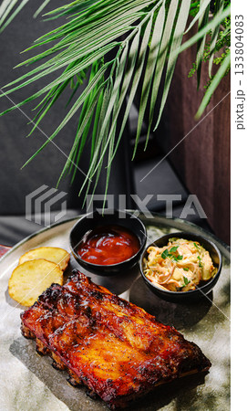 Mouthwatering barbecue ribs served with sides at a cozy restaurant Mouthwatering barbecue ribs served with sides at a cozy restaurant 133804083