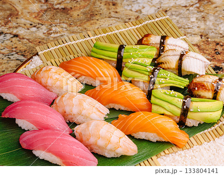 Sushi platter featuring salmon, tuna, and fresh avocado rolls 133804141
