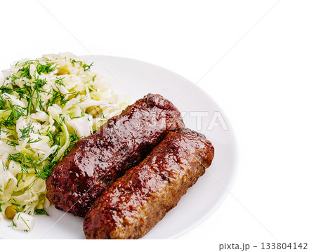 Juicy grilled meat sausages served with fresh cabbage salad Juicy grilled meat sausages served with fresh cabbage salad 133804142