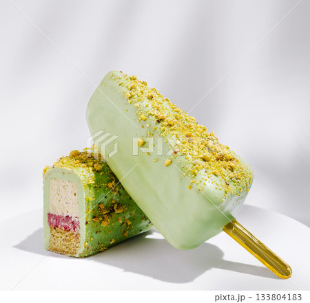 Delicious green dessert popsicle with pistachio topping and creamy filling 133804183