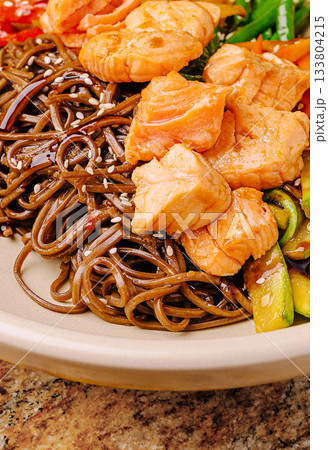 Delicious salmon soba noodles served with fresh vegetables at dinner 133804215