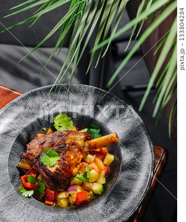 Delicious lamb dish with fresh vegetables served on a stylish plate 133804284