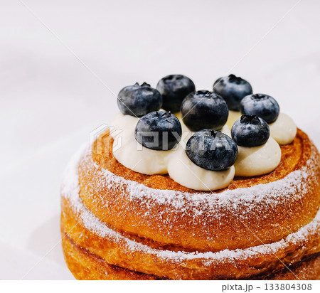 Delicious pastry topped with fresh blueberries and cream for dessert Delicious pastry topped with fresh blueberries and cream for dessert 133804308