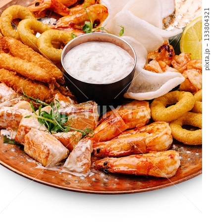 Seafood platter with shrimp, fish, and dipping sauce served on a copper plate Seafood platter with shrimp, fish, and dipping sauce served on a copper plate 133804321