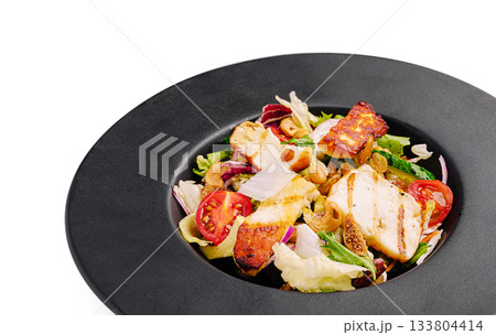 Grilled chicken salad served on a black plate with fresh vegetables Grilled chicken salad served on a black plate with fresh vegetables 133804414