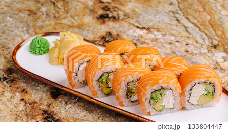 Fresh sushi rolls served on elegant plate with wasabi and ginger garnish 133804447
