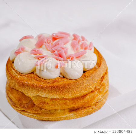 Delicious dessert with cream and pink toppings placed on a white surface 133804485
