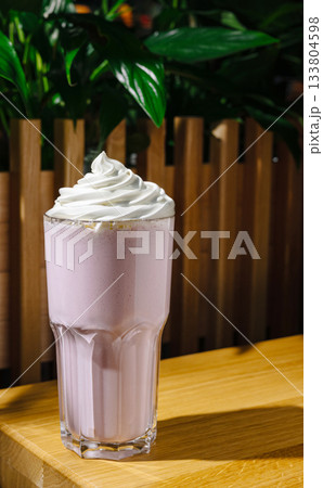 Refreshing milkshake topped with whipped cream in a cozy cafe setting Refreshing milkshake topped with whipped cream in a cozy cafe setting 133804598