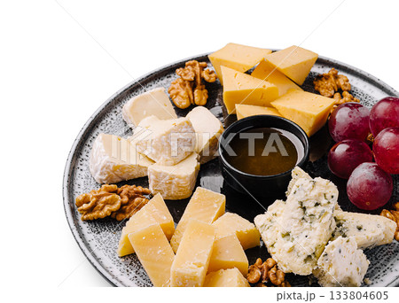 Delicious cheese platter with grapes, nuts, and honey for a perfect snack 133804605