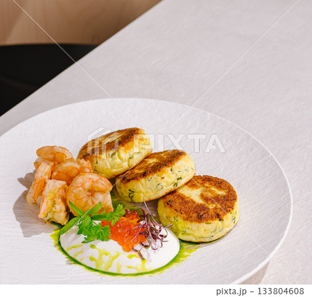 Delicious seafood dish featuring shrimp and creamy cakes served on a plate 133804608