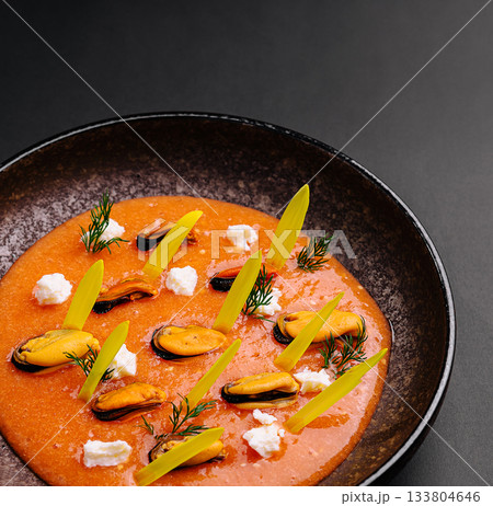 Colorful seafood dish served in a dark bowl with vibrant ingredients 133804646