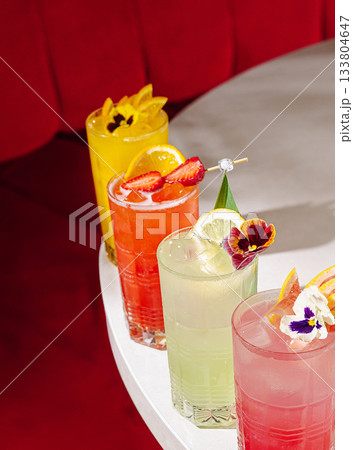 Colorful cocktails on a table in a vibrant bar during a lively evening 133804647