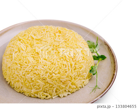 Delicious yellow rice served on a plate with fresh herbs 133804655