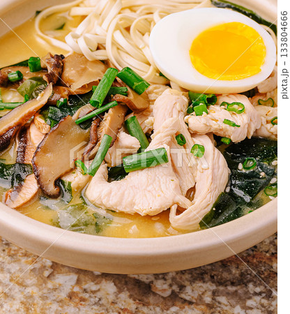 Warm chicken noodle soup with vegetables and soft egg in a bowl Warm chicken noodle soup with vegetables and soft egg in a bowl 133804666