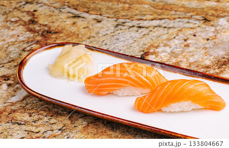 Fresh salmon sushi served on white plate with ginger Fresh salmon sushi served on white plate with ginger 133804667
