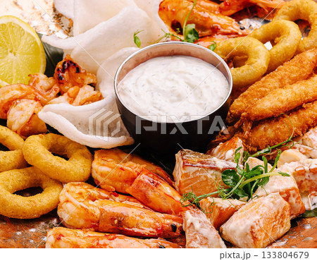 Fresh seafood platter with shrimp, fish, and dipping sauce enjoyed at dinner 133804679