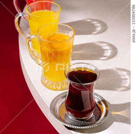 Colorful drinks displayed on a table with vibrant shadows in a cozy setting 133804786