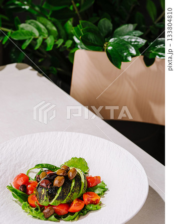 Healthy salad with grilled vegetables on a white plate in a modern setting 133804810
