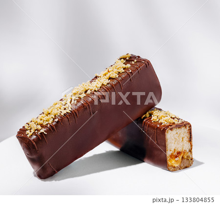 Chocolate-covered dessert bars with nut topping and soft filling Chocolate-covered dessert bars with nut topping and soft filling 133804855