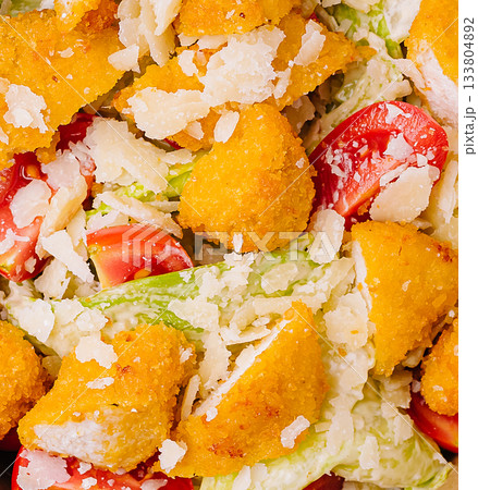 Delicious salad with crispy chicken, fresh vegetables, and cheese topping Delicious salad with crispy chicken, fresh vegetables, and cheese topping 133804892