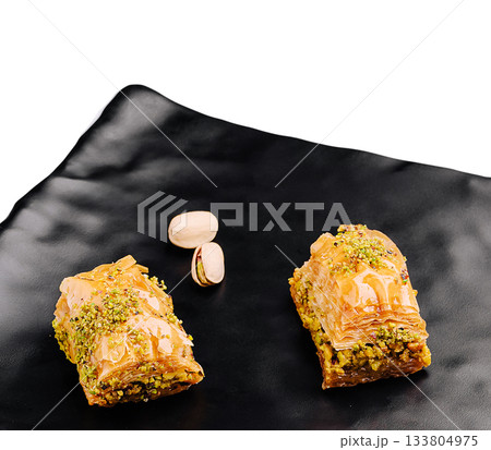 Baklava pieces with pistachios on a black plate Baklava pieces with pistachios on a black plate 133804975