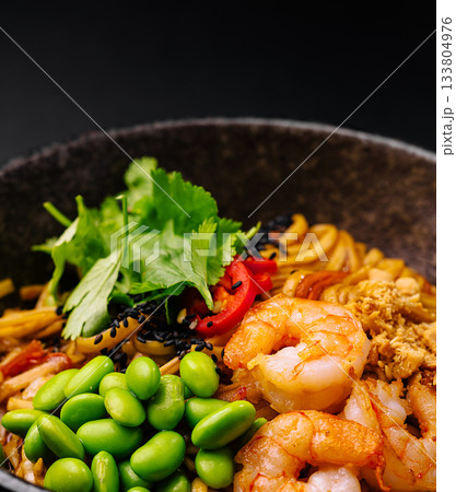 Delicious bowl of noodles with shrimp, edamame, and fresh herbs 133804976