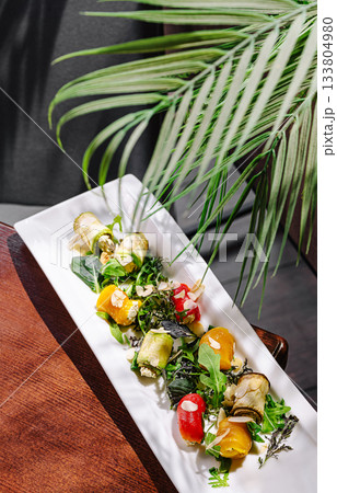 Colorful vegetable dish served on a white plate with fresh greens and herbs Colorful vegetable dish served on a white plate with fresh greens and herbs 133804980