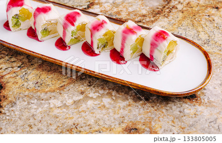 Colorful dessert sushi served on beautiful plate with rich toppings Colorful dessert sushi served on beautiful plate with rich toppings 133805005
