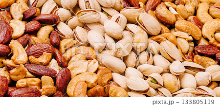 Mixed nuts displayed on a wooden surface with various textures and colors Mixed nuts displayed on a wooden surface with various textures and colors 133805119