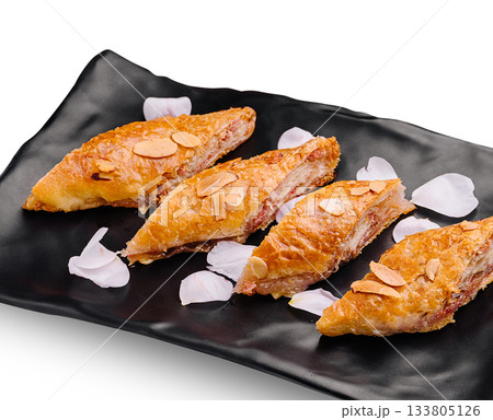 Delicious pastry filled with nuts served on a black plate Delicious pastry filled with nuts served on a black plate 133805126