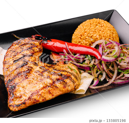 Grilled chicken with spicy pepper and rice served on a black plate 133805198