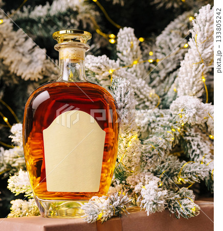 Holiday spirit with a decorative bottle placed by a winter tree Holiday spirit with a decorative bottle placed by a winter tree 133805242