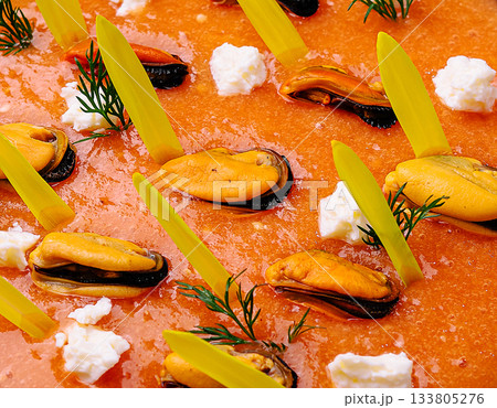 Colorful seafood dish with mussels and herbs on a vibrant sauce Colorful seafood dish with mussels and herbs on a vibrant sauce 133805276