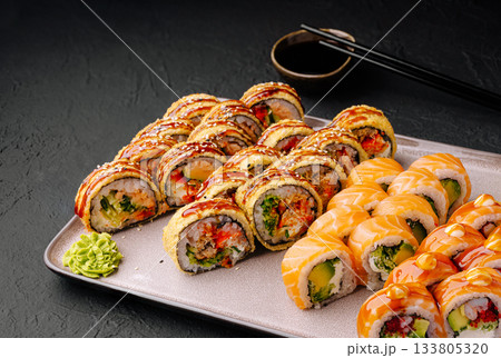 Delicious sushi rolls displayed on a plate with dipping sauce and wasabi Delicious sushi rolls displayed on a plate with dipping sauce and wasabi 133805320