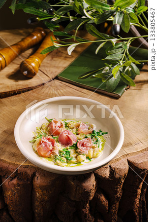 Gourmet dish featuring ham and greens served on rustic wooden table Gourmet dish featuring ham and greens served on rustic wooden table 133805467
