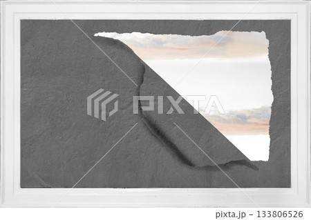 Rip on wall showing bright sky 133806526