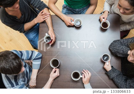 People sitting around table drinking coffee 133806633