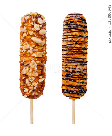 Delicious dessert treats on sticks featuring nuts and chocolate drizzle Delicious dessert treats on sticks featuring nuts and chocolate drizzle 133806945