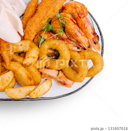 Seafood platter with shrimp, fried fish, and crunchy sides served on a plate Seafood platter with shrimp, fried fish, and crunchy sides served on a plate 133807018
