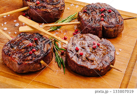 Delicious grilled beef skewers served on a wooden board 133807019