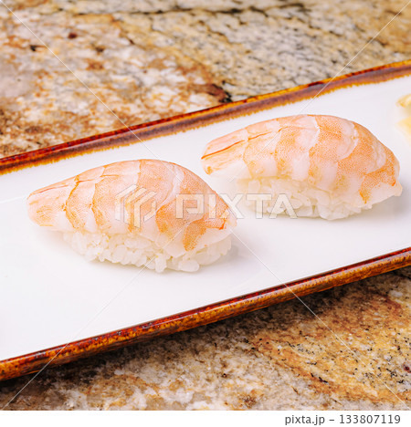 Delicate shrimp sushi served on a white plate at a sushi restaurant Delicate shrimp sushi served on a white plate at a sushi restaurant 133807119