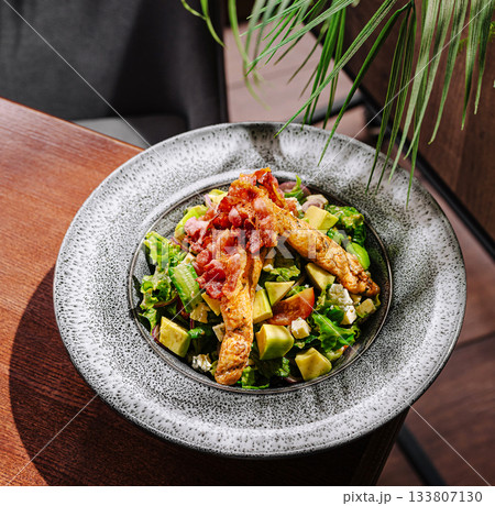 Fresh salad with grilled chicken and avocado served in modern restaurant setting Fresh salad with grilled chicken and avocado served in modern restaurant setting 133807130