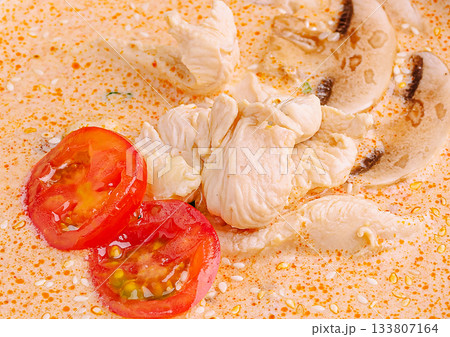Spicy chicken soup with tomatoes and mushrooms in a warm bowl 133807164