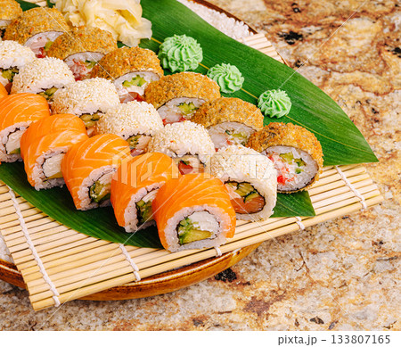 Freshly prepared sushi rolls arranged beautifully on a bamboo mat 133807165
