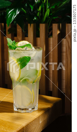 Refreshing mojito cocktail served in a tall glass with mint leaves and lime 133807175