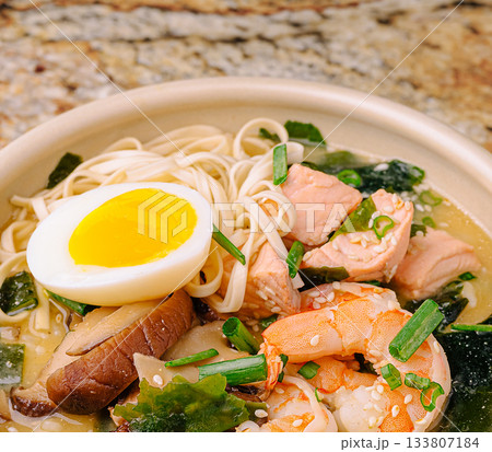 Delicious bowl of ramen with shrimp, salmon, egg, and vegetables 133807184