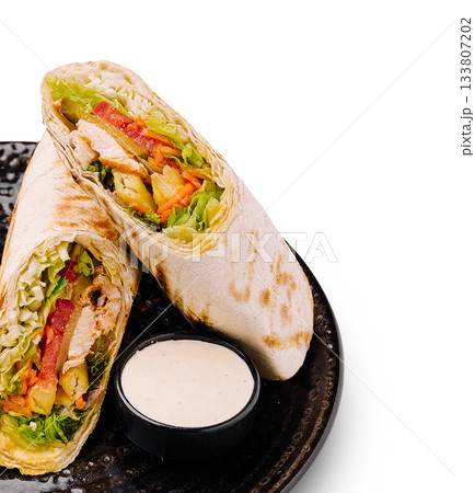 Cooking healthy wrap with grilled chicken and fresh vegetables served on a plate Cooking healthy wrap with grilled chicken and fresh vegetables served on a plate 133807202