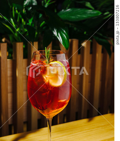 Refreshing cocktail served in a clear glass with lemon and rosemary garnish 133807216